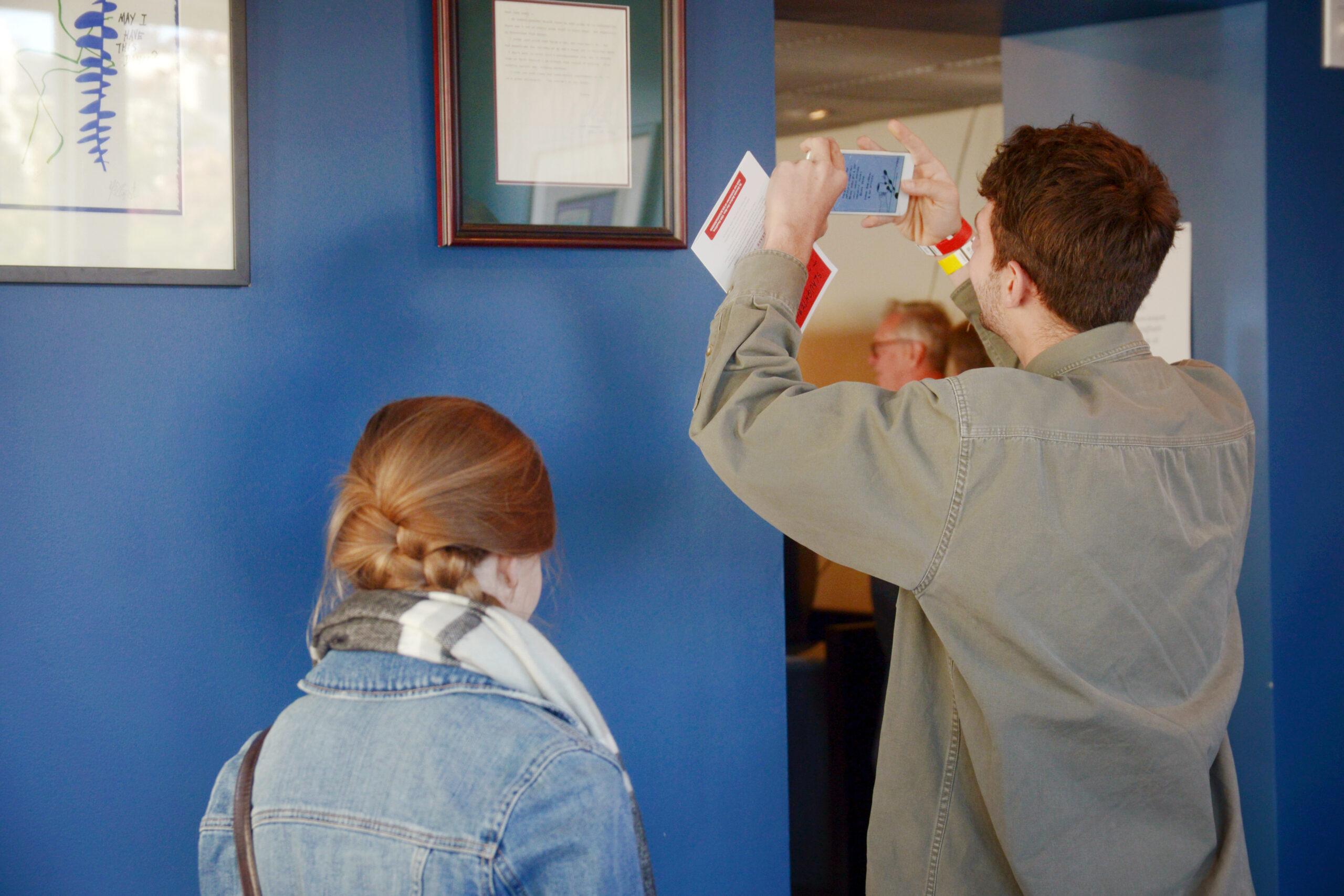 A person taking a photo of a framed image